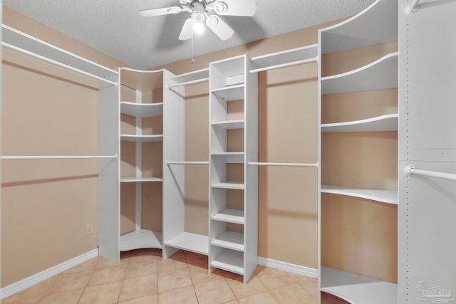 spacious closet with ceiling fan and tile patterned flooring