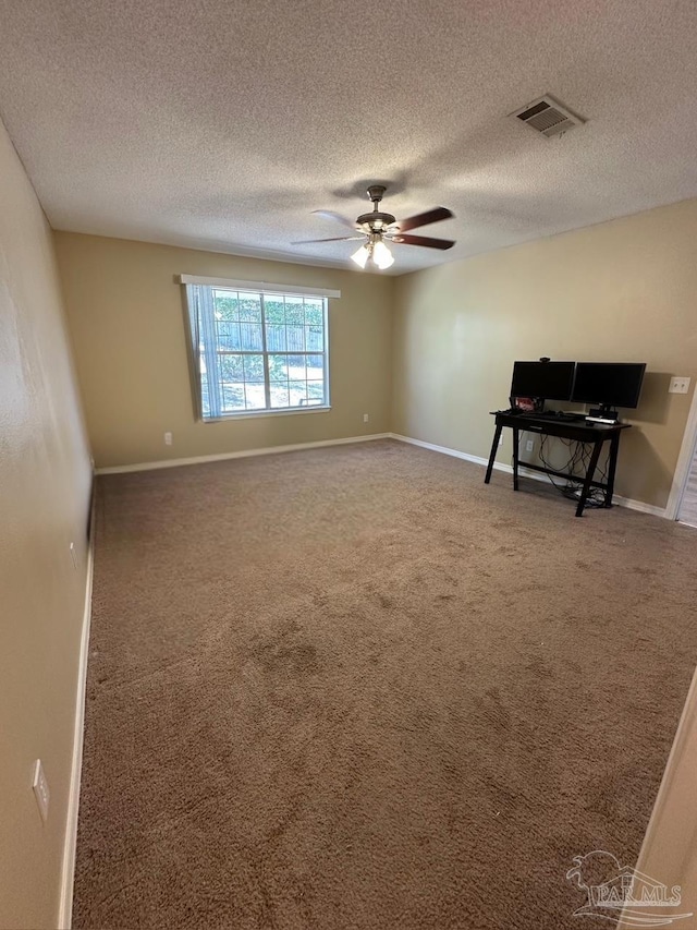 carpeted spare room with ceiling fan and a textured ceiling