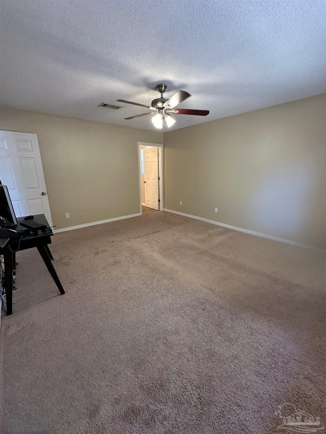 spare room featuring ceiling fan, carpet floors, and a textured ceiling