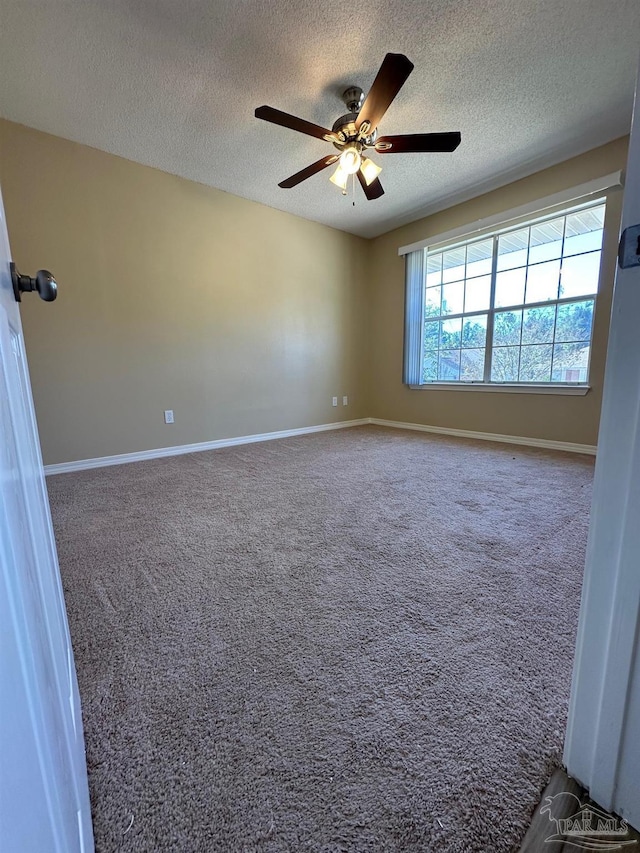 carpeted empty room with ceiling fan and a textured ceiling