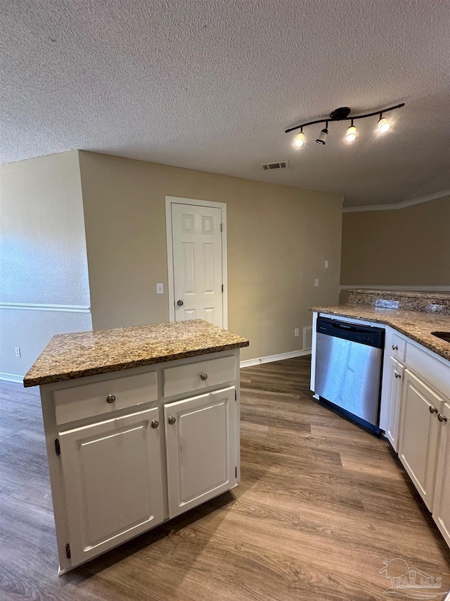 kitchen featuring dishwasher, a center island, white cabinets, a textured ceiling, and light stone counters