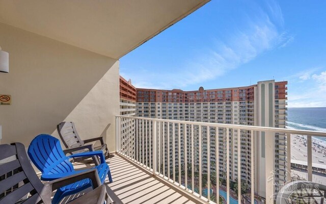 balcony featuring a beach view and a water view