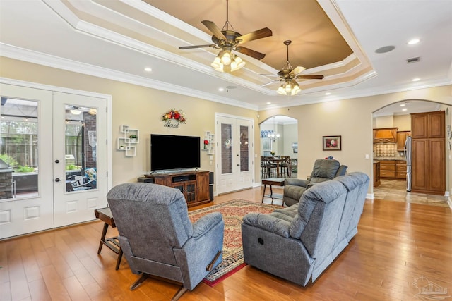 2882 Tunnel Rd, Pace, FL 32571 - living area featuring arched walkways, a raised ceiling, a ceiling fan, light wood-style flooring, and crown molding