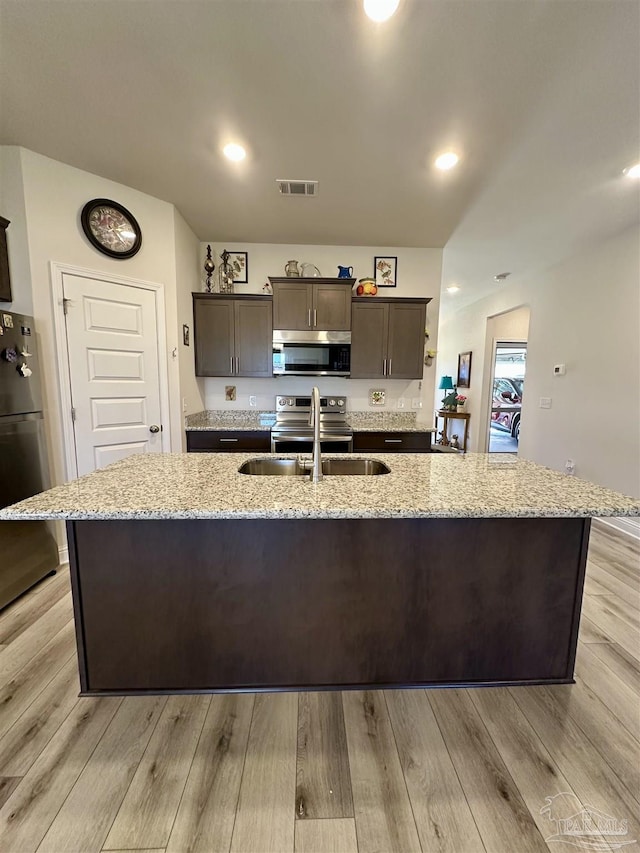 2656 Avalon St, Cantonment, FL 32533 - kitchen featuring visible vents, a center island with sink, dark brown cabinets, a sink, and stainless steel appliances
