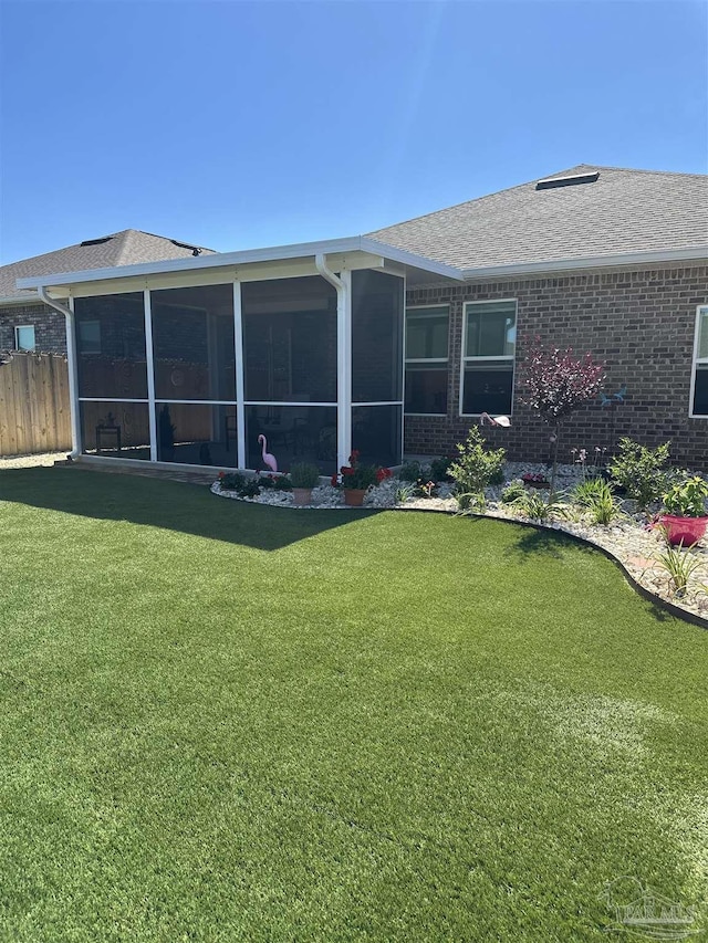 2656 Avalon St, Cantonment, FL 32533 - back of house featuring fence, a yard, a shingled roof, and a sunroom