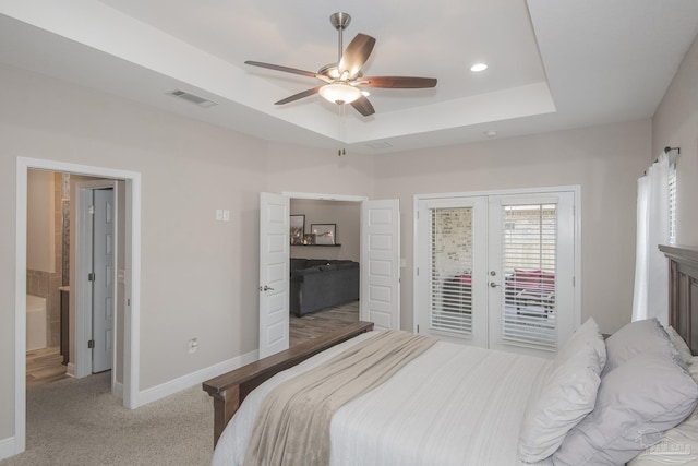 bedroom featuring access to exterior, baseboards, a tray ceiling, and french doors