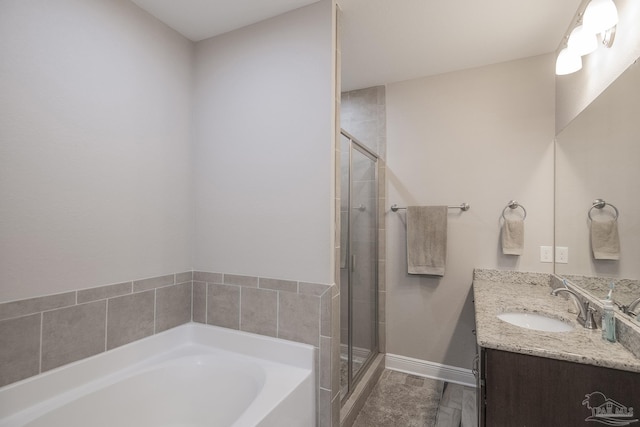 full bathroom featuring a garden tub, a shower stall, vanity, and baseboards