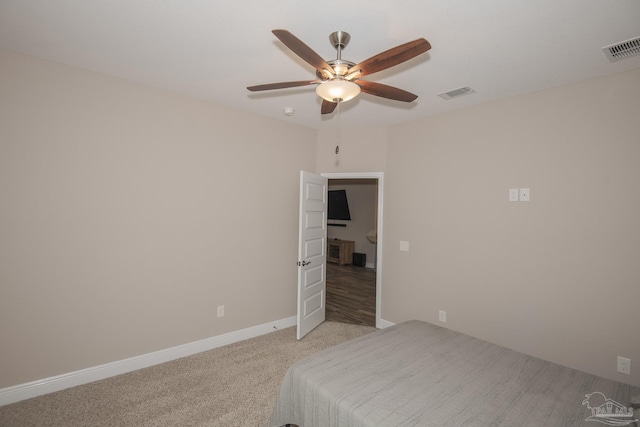 bedroom featuring baseboards, ceiling fan, visible vents, and light colored carpet