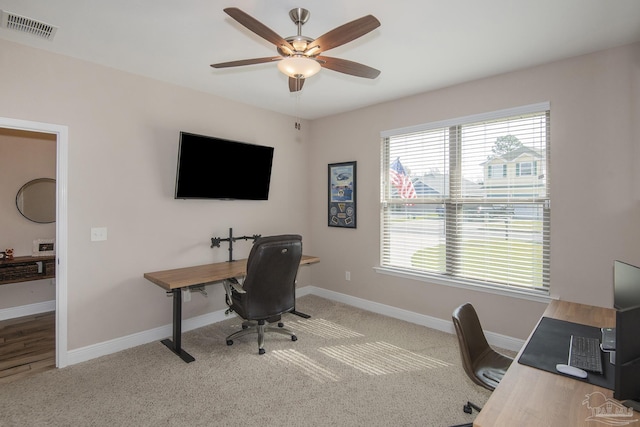 carpeted office featuring a ceiling fan, visible vents, and baseboards