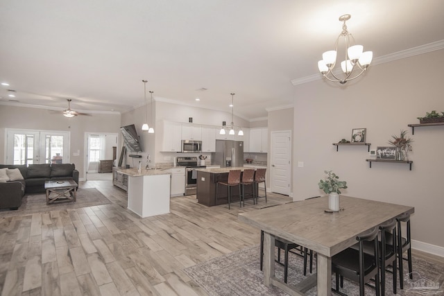 dining area featuring crown molding, light wood finished floors, recessed lighting, baseboards, and ceiling fan with notable chandelier