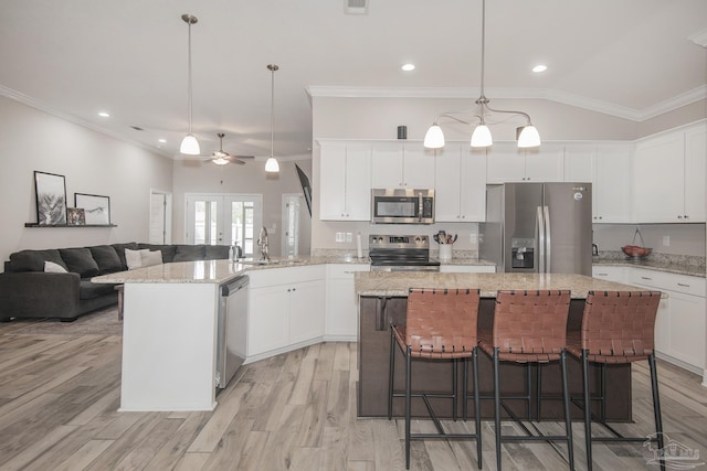 kitchen featuring light wood-style flooring, appliances with stainless steel finishes, white cabinets, and crown molding