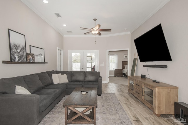 living area featuring ornamental molding, french doors, light wood-style flooring, and visible vents