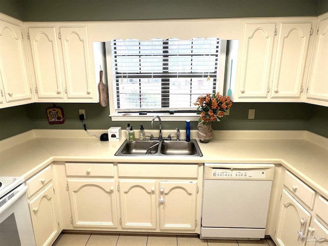 kitchen with sink, dishwasher, and light tile patterned floors