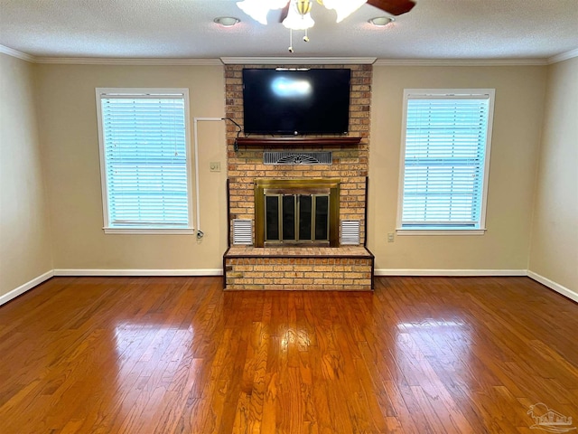 unfurnished living room featuring a brick fireplace, a textured ceiling, and a wealth of natural light