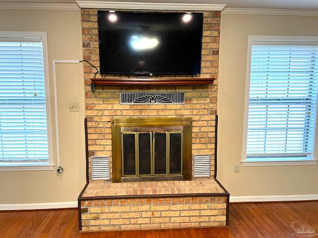 room details featuring a fireplace, crown molding, and hardwood / wood-style floors