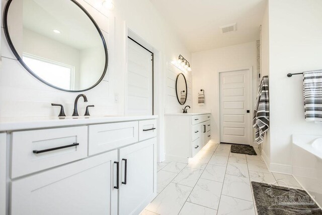 bathroom featuring vanity, tile patterned flooring, and a tub to relax in