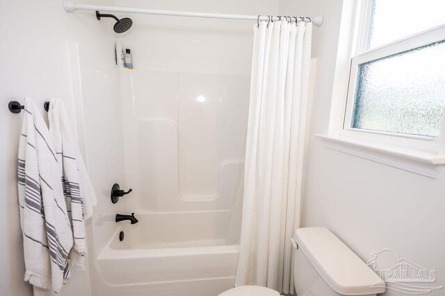 bathroom with toilet, shower / bathtub combination with curtain, and plenty of natural light