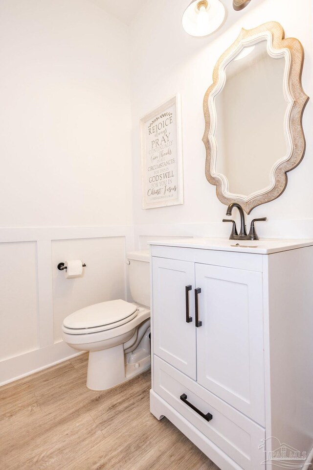 bathroom featuring vanity, wood-type flooring, and toilet