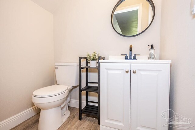 bathroom with vanity, toilet, and hardwood / wood-style floors