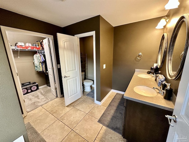 2924 Sundance Ln, Cantonment, FL 32533 - bathroom featuring double vanity, tile patterned floors, and a walk in closet