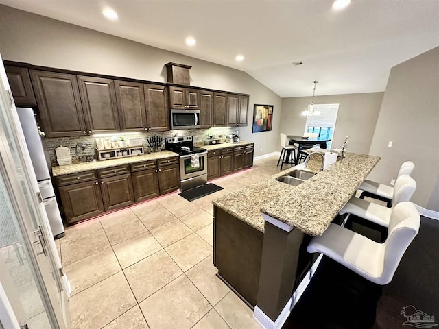2924 Sundance Ln, Cantonment, FL 32533 - kitchen featuring stainless steel appliances, lofted ceiling, tasteful backsplash, light tile patterned floors, and a kitchen bar
