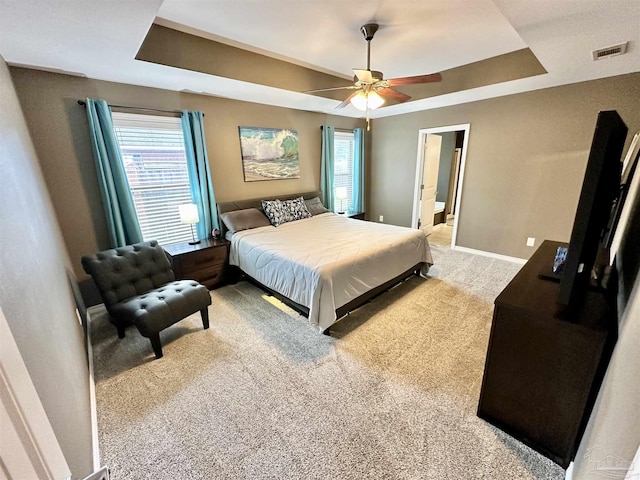 2924 Sundance Ln, Cantonment, FL 32533 - bedroom with a tray ceiling, light colored carpet, multiple windows, and a ceiling fan