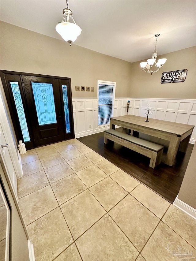 2924 Sundance Ln, Cantonment, FL 32533 - tiled dining area with a chandelier, a decorative wall, and a wainscoted wall