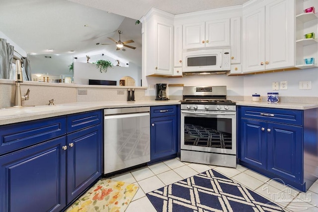 kitchen with lofted ceiling, white cabinets, blue cabinets, ceiling fan, and stainless steel appliances