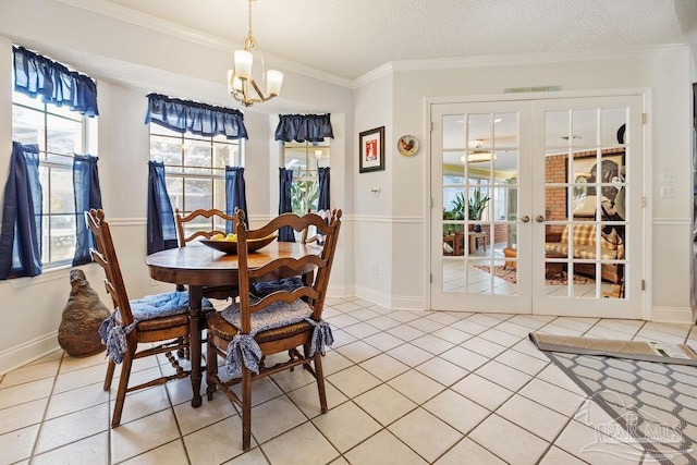 tiled dining space with french doors, a textured ceiling, crown molding, and a notable chandelier