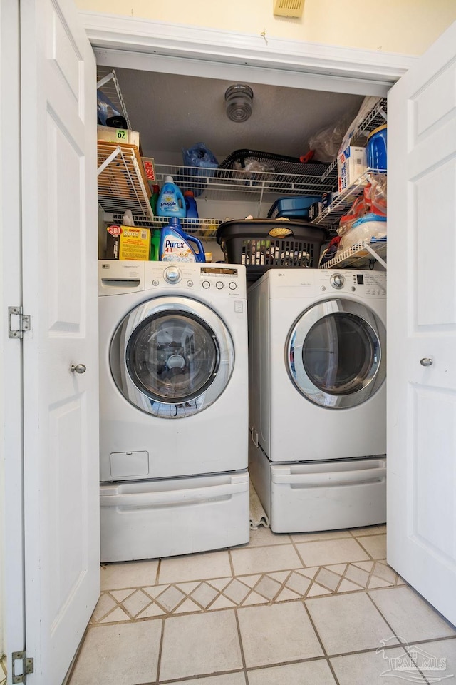 laundry room featuring separate washer and dryer and tile patterned floors