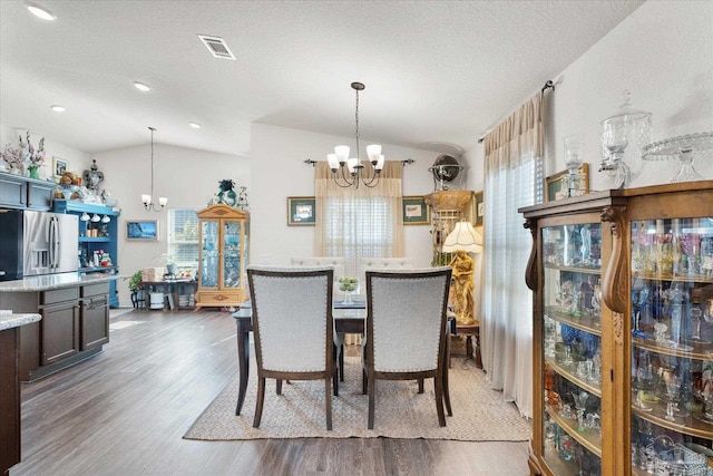 6135 Redberry Dr, Gulf Breeze, FL 32563 - dining space with a chandelier, lofted ceiling, wood finished floors, a textured ceiling, and recessed lighting