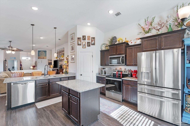 6135 Redberry Dr, Gulf Breeze, FL 32563 - kitchen with stainless steel appliances, open floor plan, dark brown cabinets, a kitchen island, and dark wood-style floors
