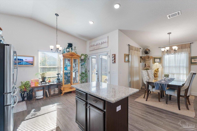 6135 Redberry Dr, Gulf Breeze, FL 32563 - kitchen with a chandelier, lofted ceiling, freestanding refrigerator, wood finished floors, and hanging light fixtures