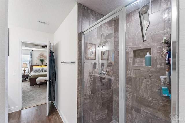 6135 Redberry Dr, Gulf Breeze, FL 32563 - ensuite bathroom featuring wood finished floors, a shower stall, and a textured ceiling
