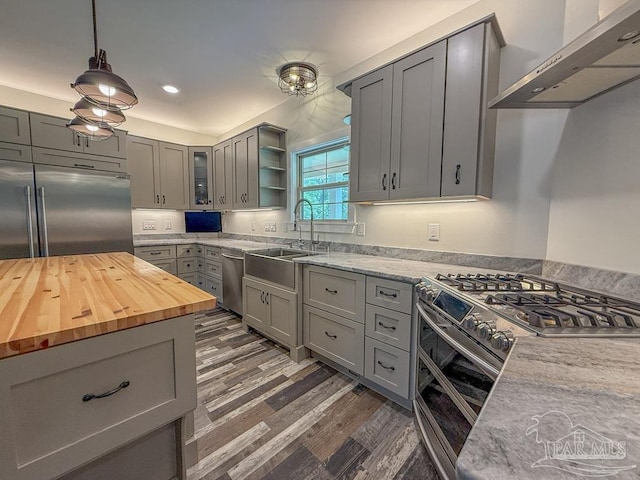 9873 Chumuckla Springs Rd, Jay, FL 32565 - kitchen featuring a sink, butcher block countertops, wall chimney exhaust hood, stainless steel appliances, and gray cabinetry