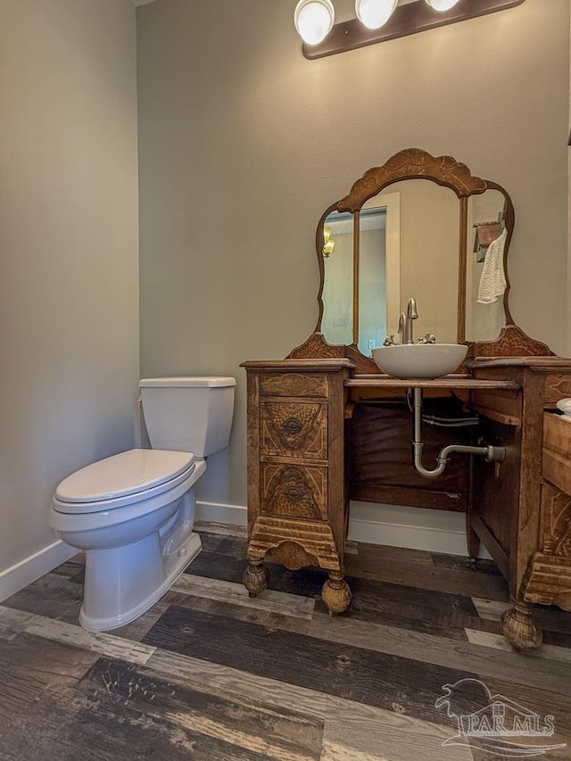 9873 Chumuckla Springs Rd, Jay, FL 32565 - half bath featuring baseboards, vanity, toilet, and wood finished floors