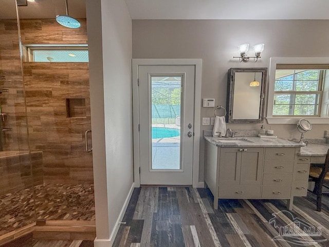 9873 Chumuckla Springs Rd, Jay, FL 32565 - bathroom with vanity, a wealth of natural light, wood finished floors, and a stall shower