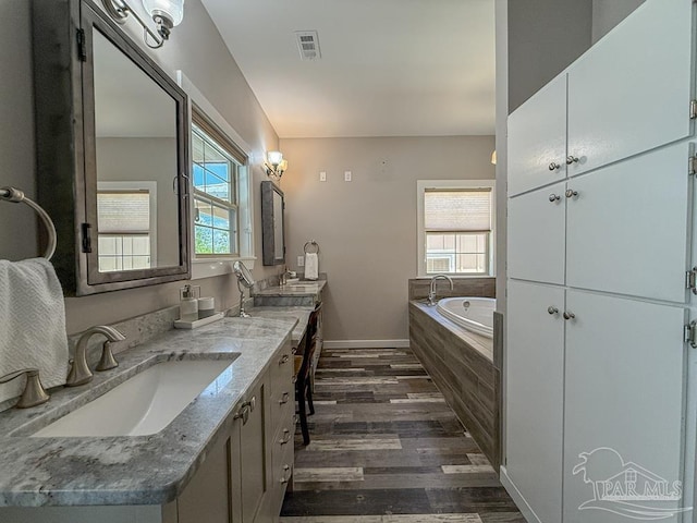 9873 Chumuckla Springs Rd, Jay, FL 32565 - bathroom featuring a garden tub, visible vents, wood finished floors, vanity, and baseboards