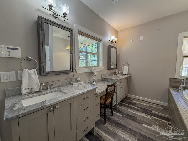 9873 Chumuckla Springs Rd, Jay, FL 32565 - full bathroom with tiled bath, baseboards, wood finished floors, and vanity