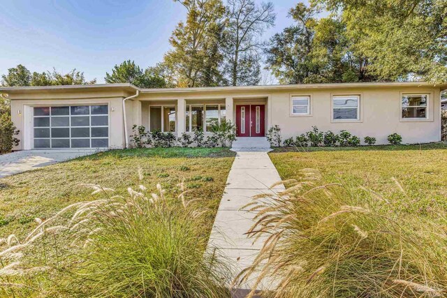 ranch-style house with a garage and a front lawn