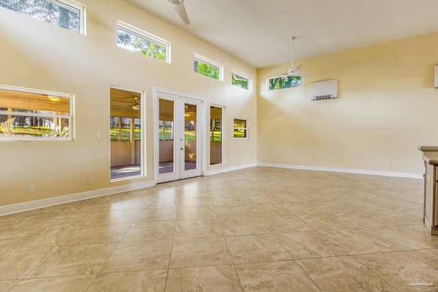 spare room with ceiling fan, french doors, and a towering ceiling