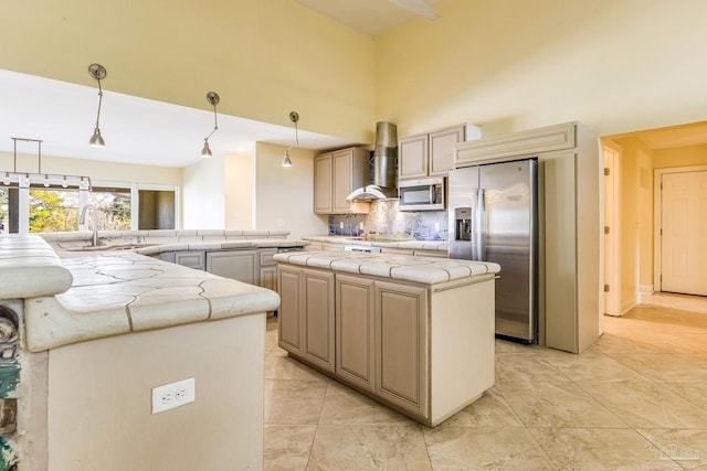 kitchen featuring appliances with stainless steel finishes, tasteful backsplash, wall chimney range hood, pendant lighting, and a center island