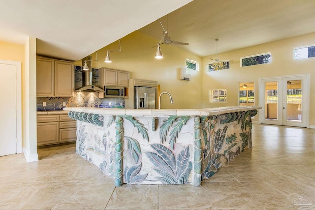 kitchen featuring light brown cabinets, stainless steel appliances, plenty of natural light, and tasteful backsplash