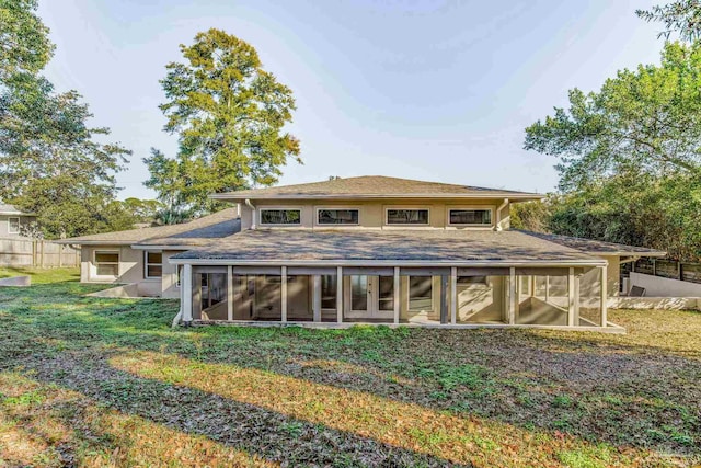 rear view of house with a yard and a sunroom