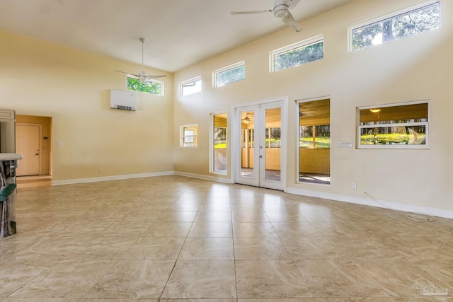 empty room with french doors, a towering ceiling, and ceiling fan