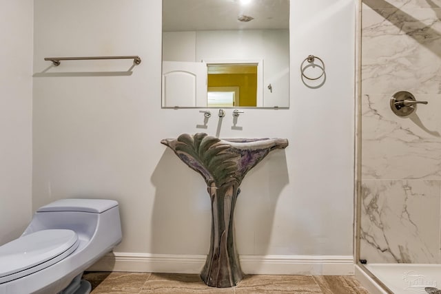 bathroom featuring tiled shower and toilet