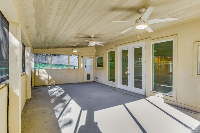 unfurnished sunroom featuring ceiling fan, french doors, and wooden ceiling