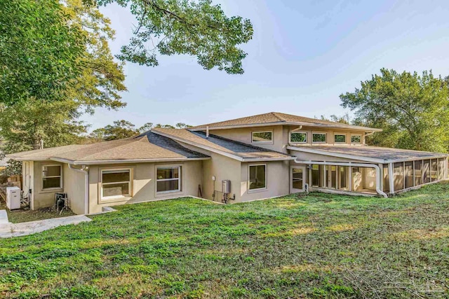 back of property with a sunroom and a yard