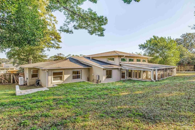 back of property featuring a yard and a sunroom