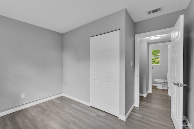 unfurnished bedroom with a closet and light wood-type flooring